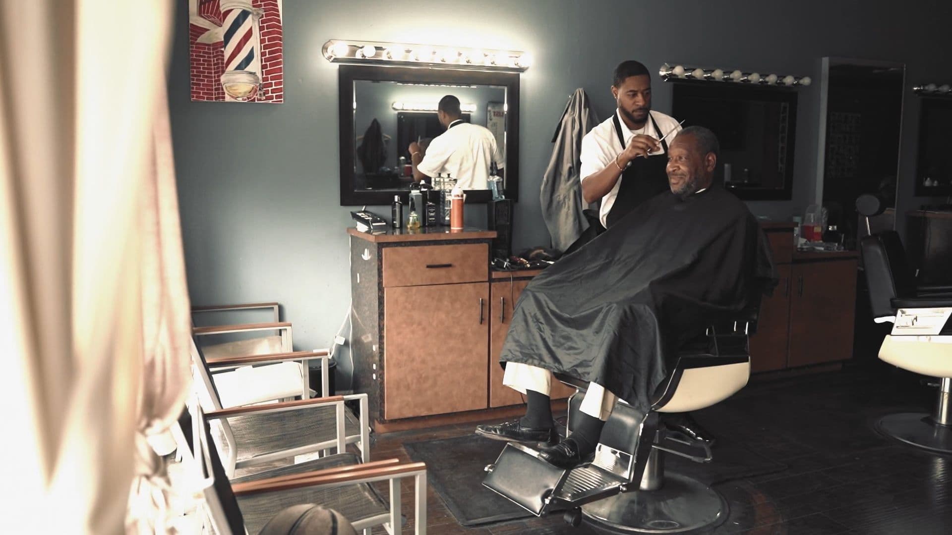 A barber styling a client’s hair in a barbershop